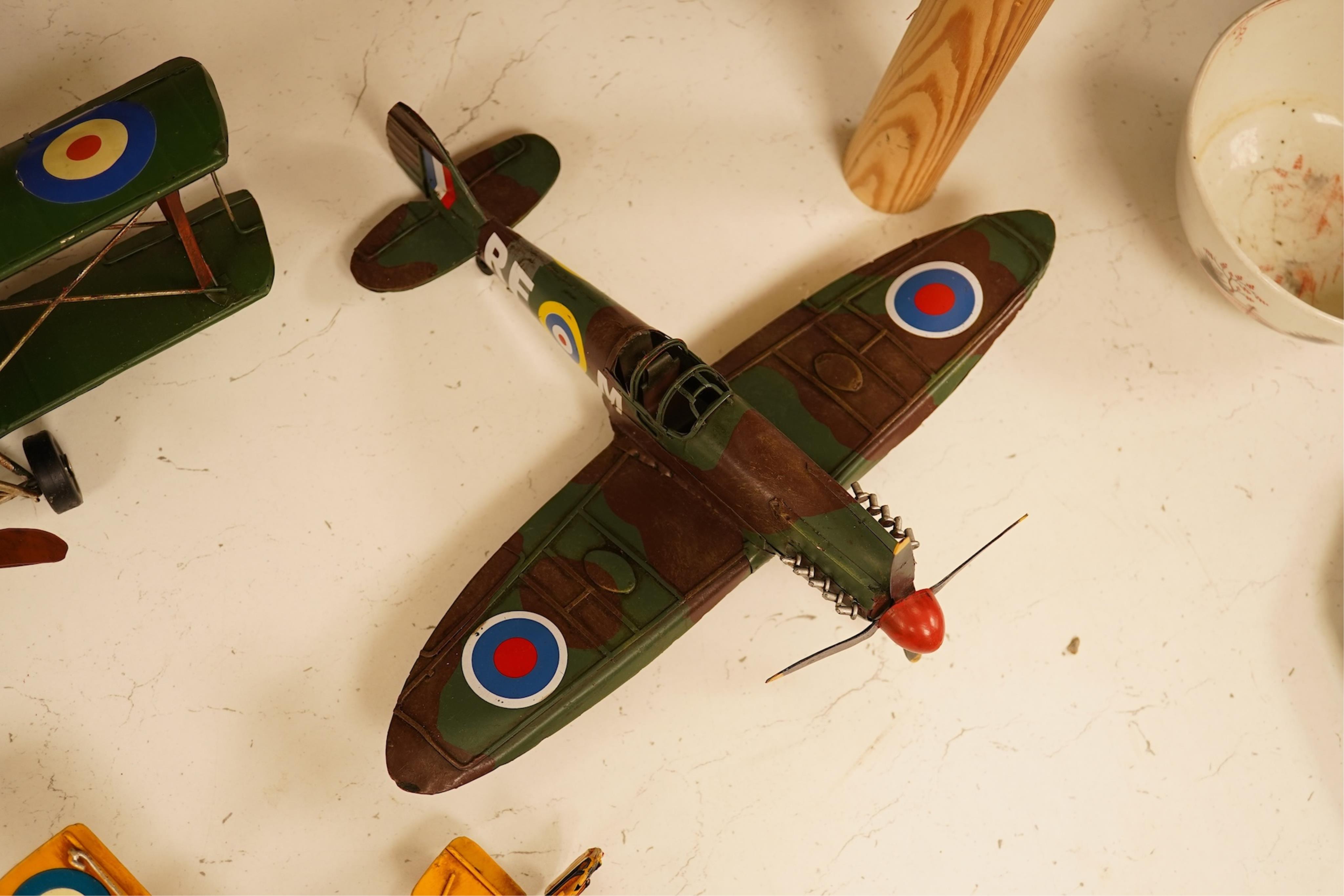 Five decorative metal models of military aircraft, including two Supermarine Spitfires, two First World War, British bi-planes, a German Albatros D.III bi-plane, and a wooden model of RMS Queen Mary, hull 77cm long